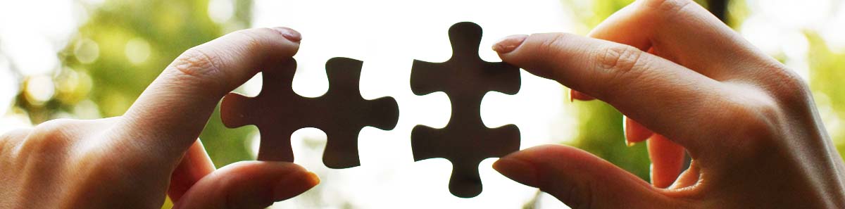 Hands holding jigsaw puzzle pieces